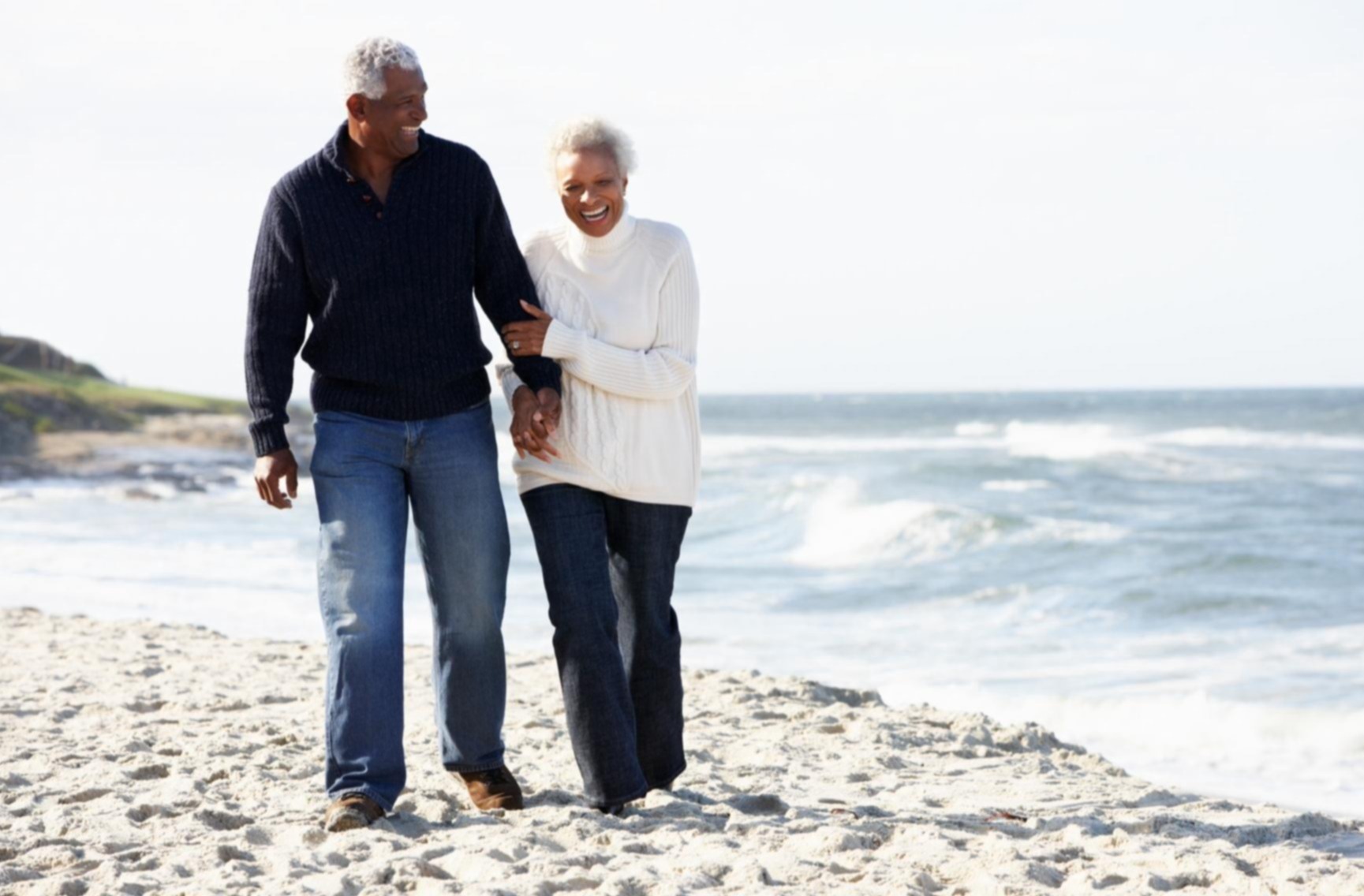 Senior couple walking along the beach together