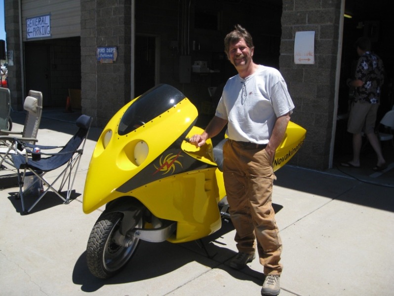 Jim Corning standing next an electric motorcycle