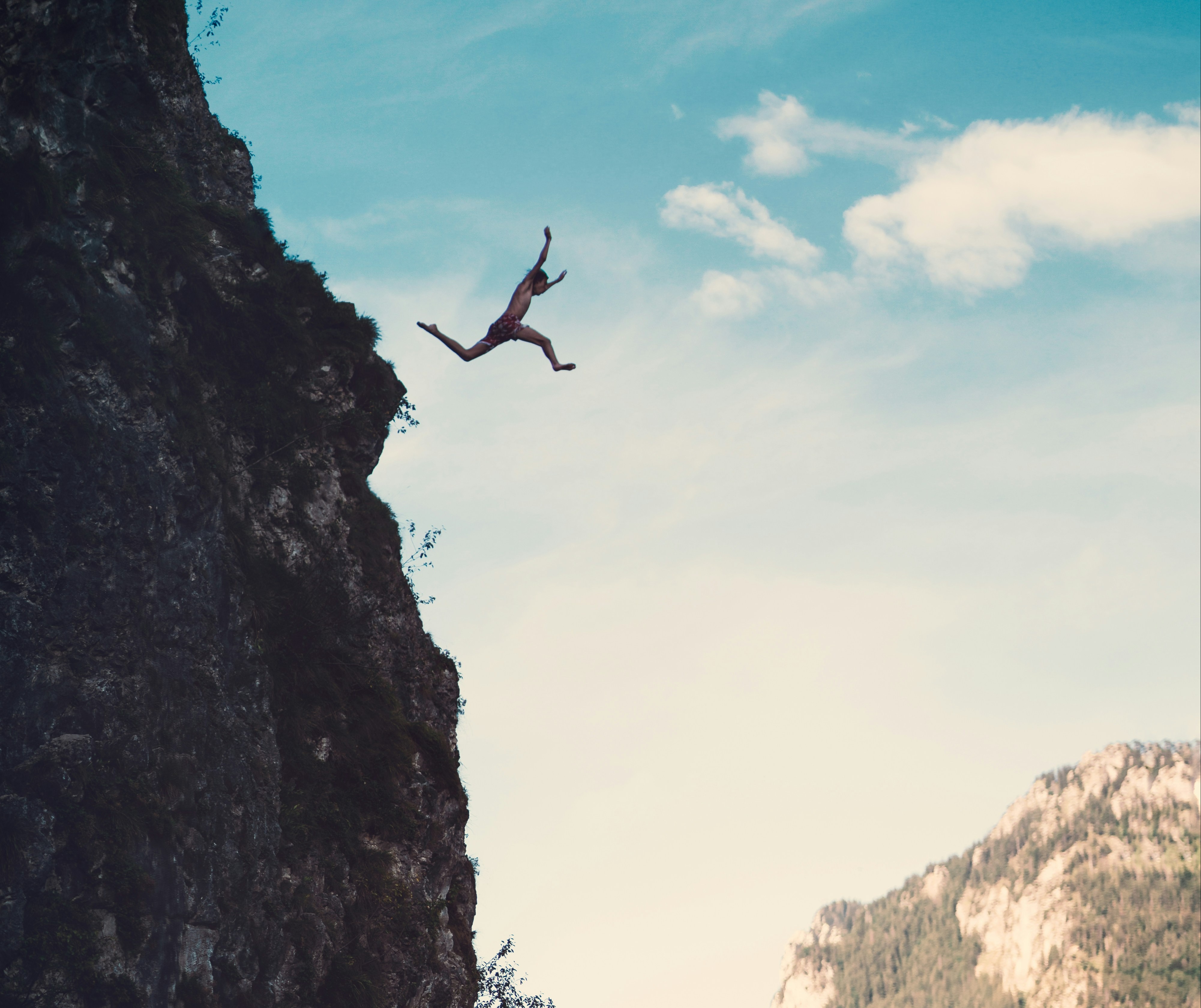 Person jumping off of a cliff.