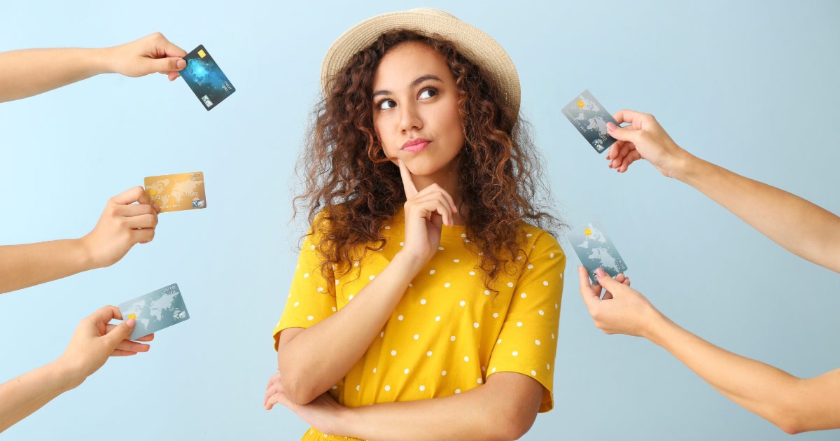 Young lady pondering while multiple arms are trying to hand her credit cards