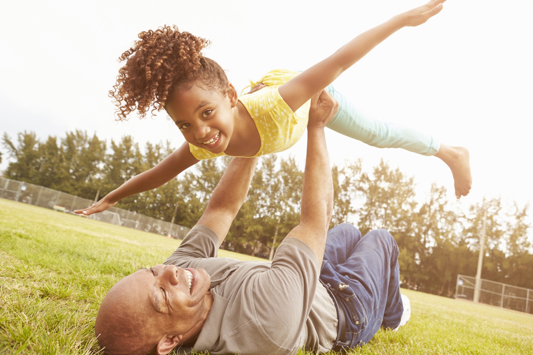 Grandfather playing with his granddaughter in the park