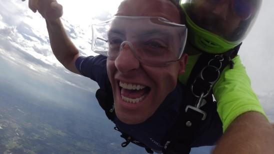 Joseph enjoys the exhilarating experience of skydiving, captured in a moment of pure joy.