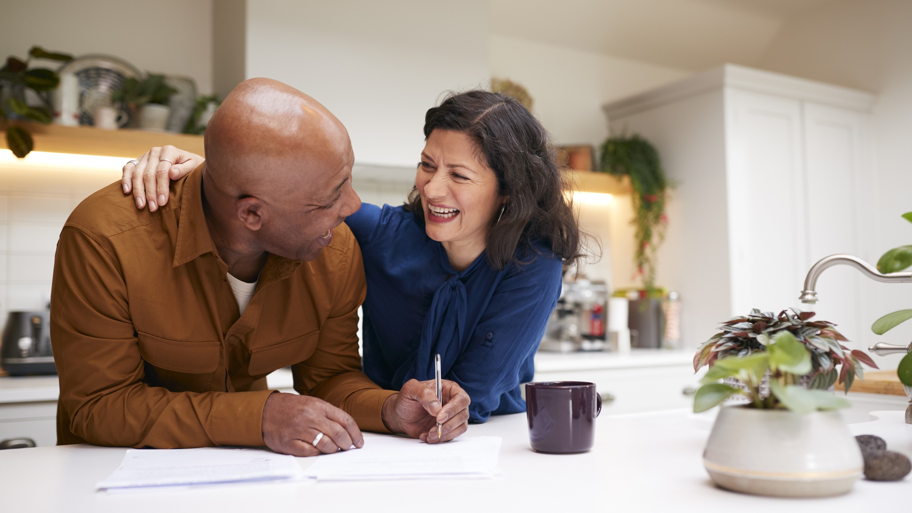 Photo of a man and woman hugging over paperwork