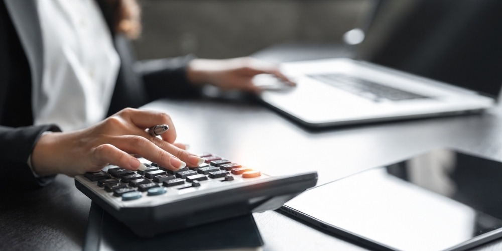 a person's hands using a desktop calculator