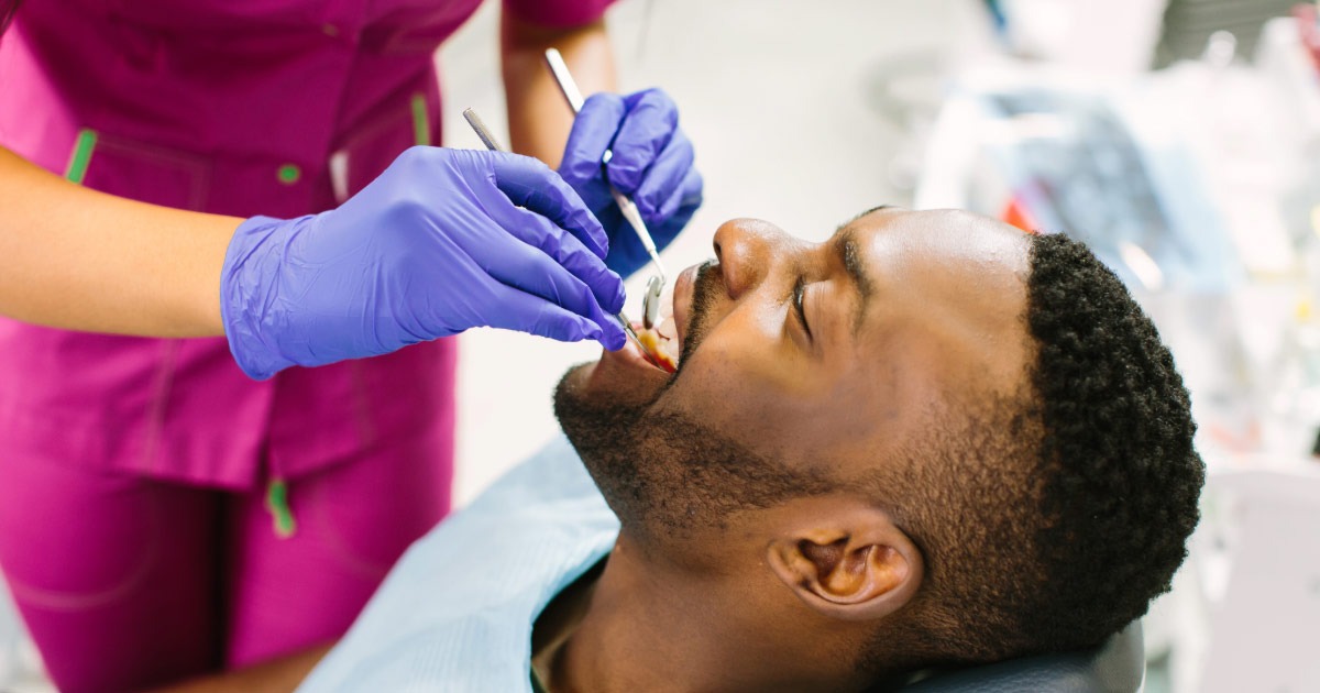 Young man sitting in dentist chair having teeth examined