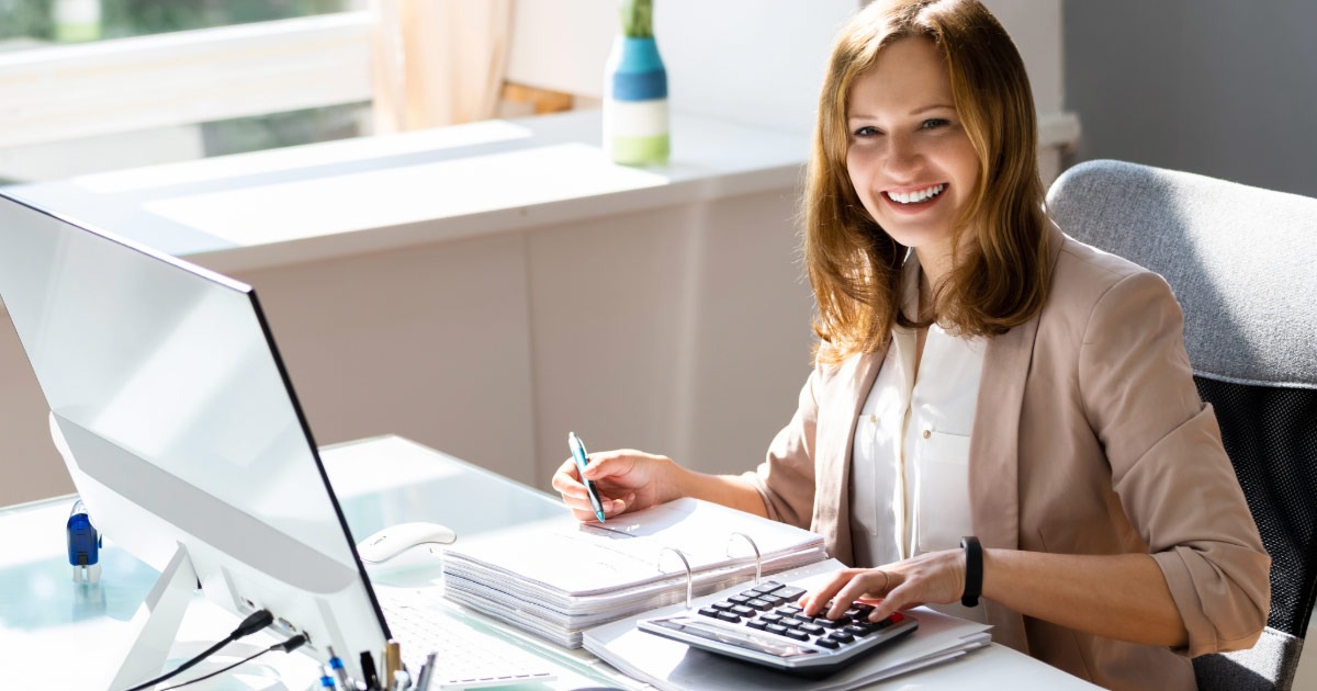 Young financial analyst calculating funds at her desk