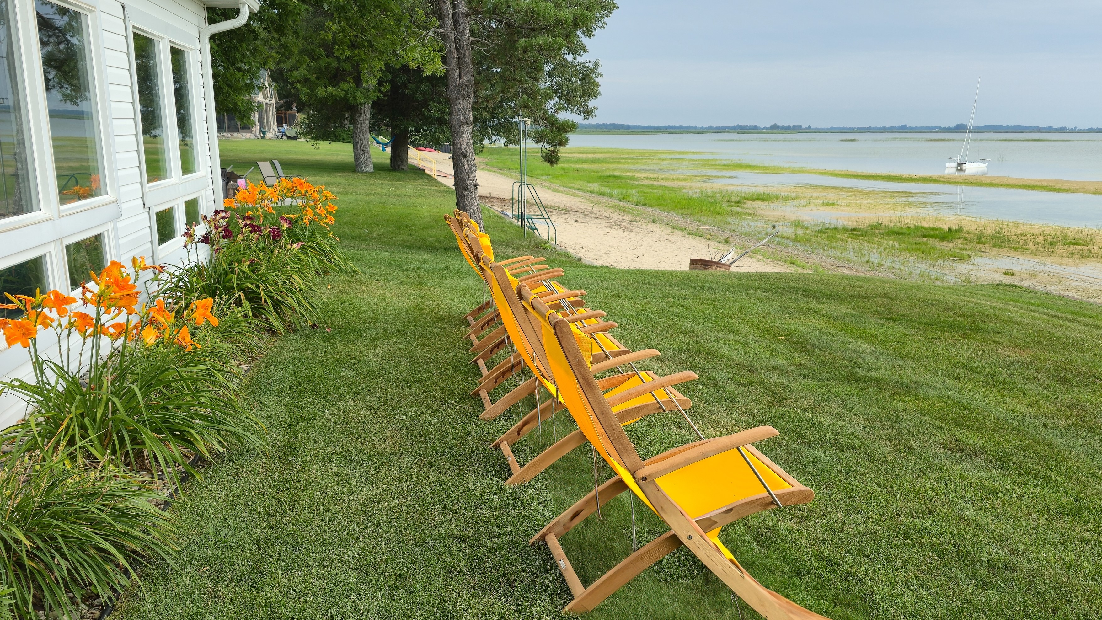 Photo image of lawn chairs lines up in front of a beach house facing the shore