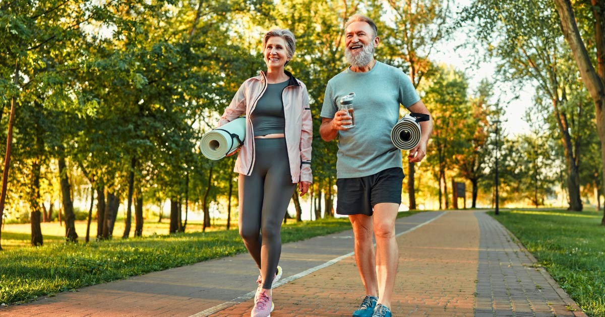 Aging couple out for a jog and yoga session in the park