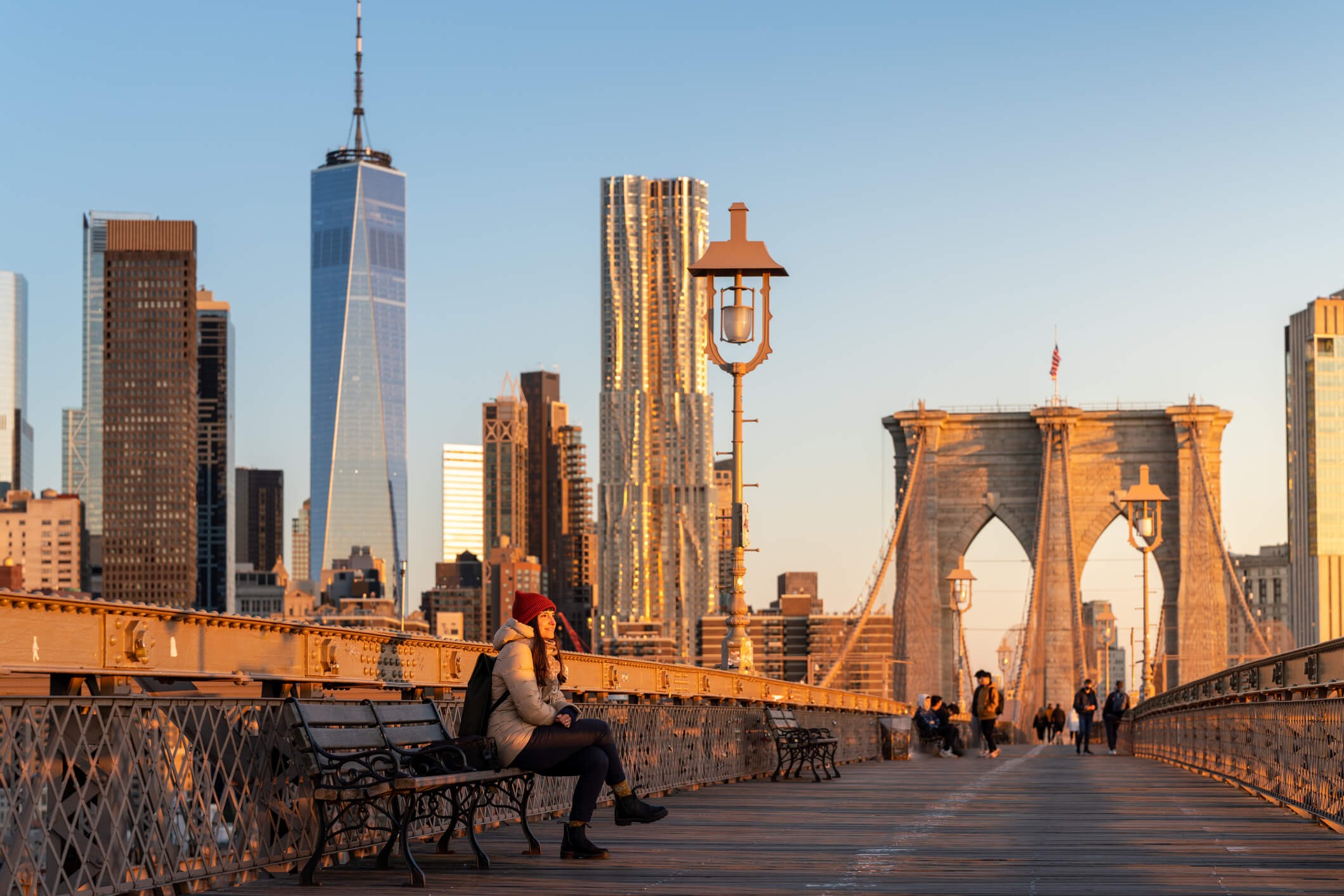 Women sitting on bench on a bridge with a modern city in the backdrop