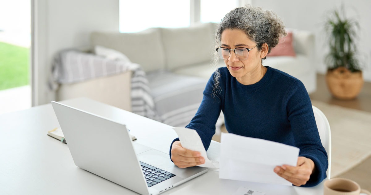 Older woman looking over bank statements and bills
