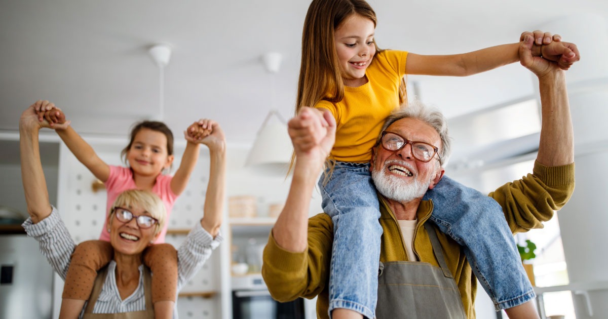 Grandparents dancing around with kids on their shoulders