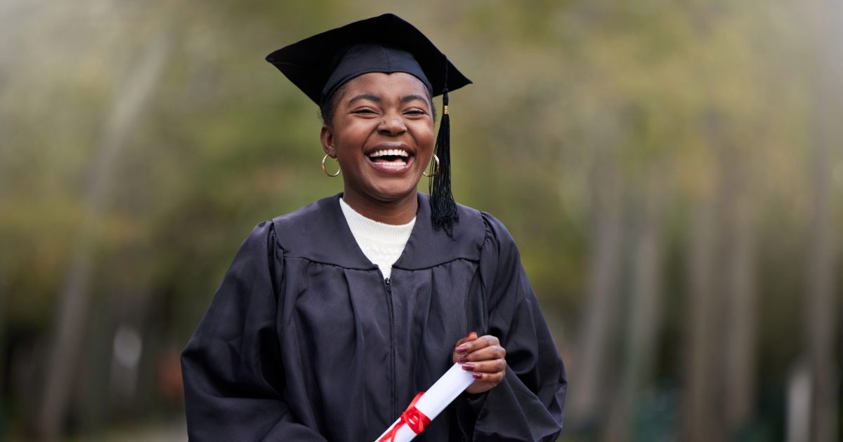 Student wearing her graduation gown and holding diploma