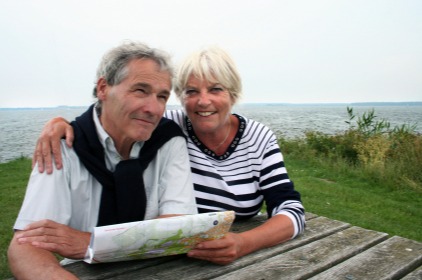 Older couple smiling in front of a scenic view