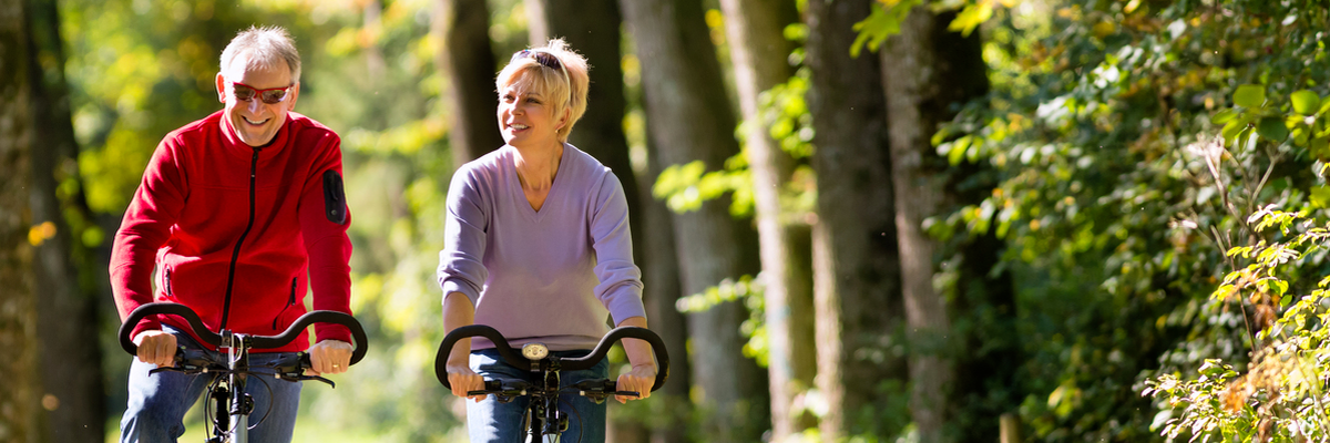 couple riding bicycles on a wooded trail