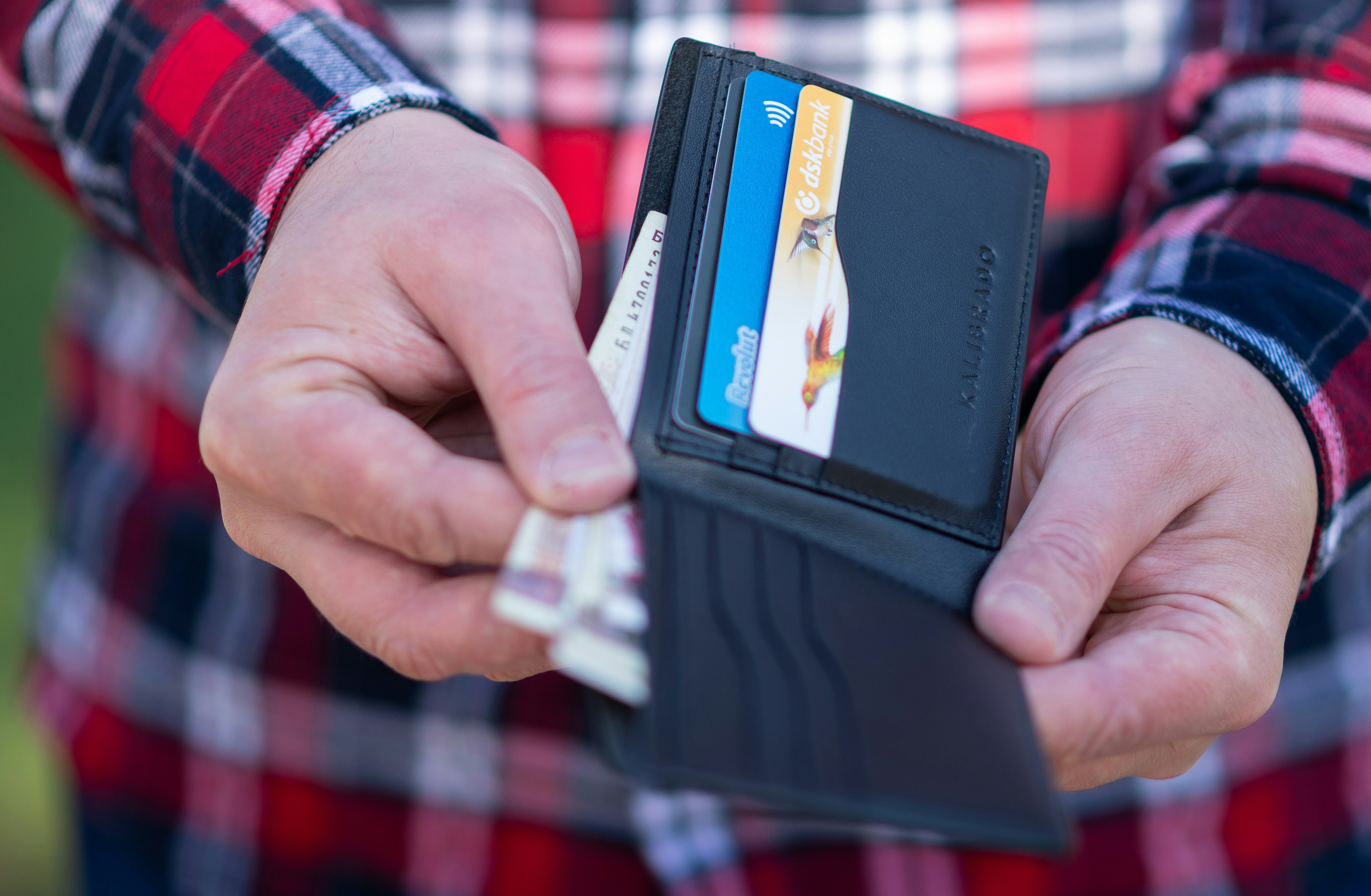 person pulling out cash from their wallet