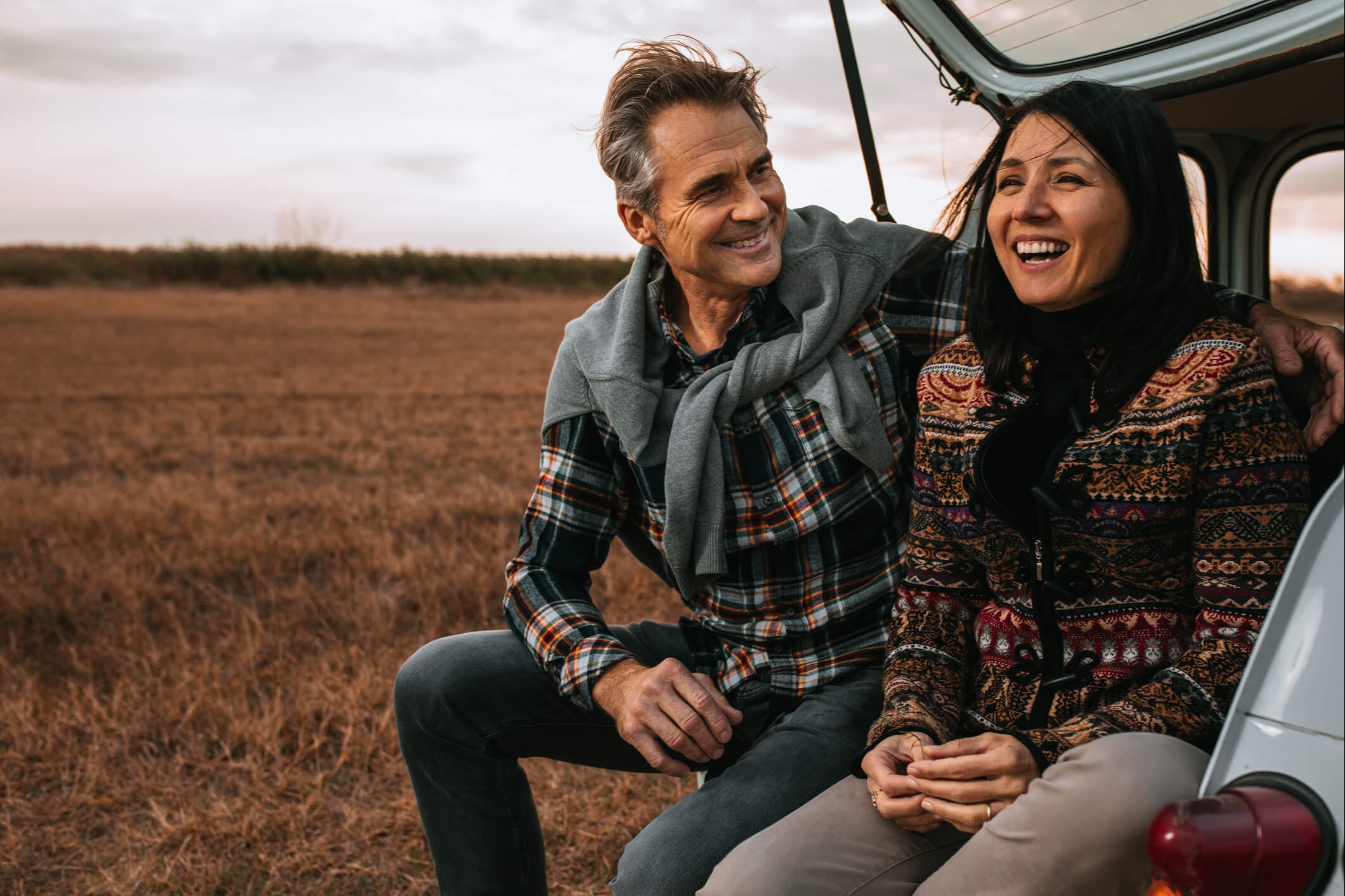 Middle age couple outdoors, enjoying nature and peace of mind knowing their cross-border financial advisor is handling their wealth plan.