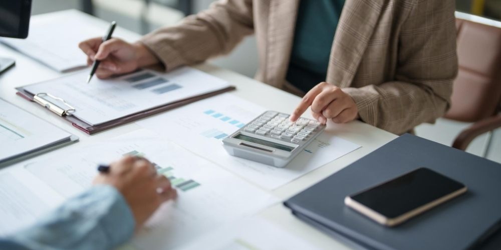 Financial advisor reviewing documents with a calculator