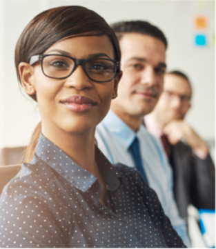 Woman in professional attire with glasses and two men in the background out of focus