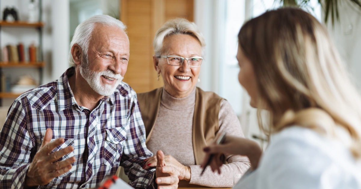 Medicare supplement scam woman speaking with older couple