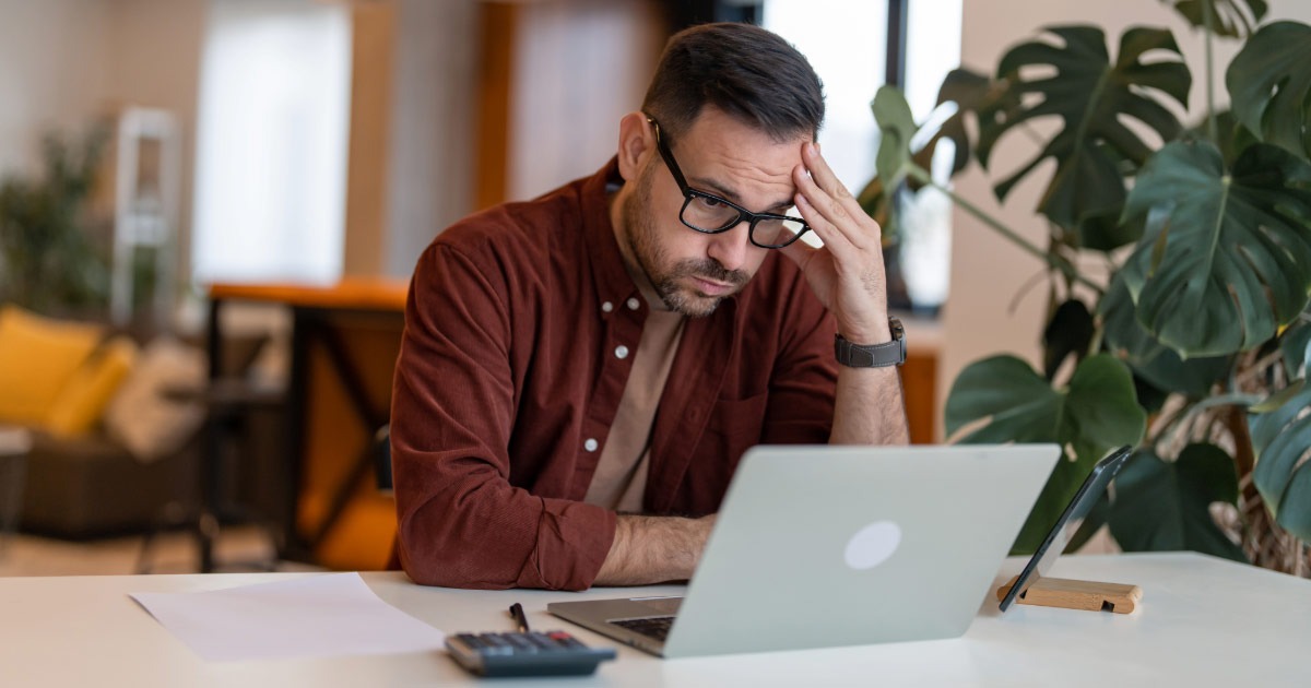 Man staring at his laptop in frustration