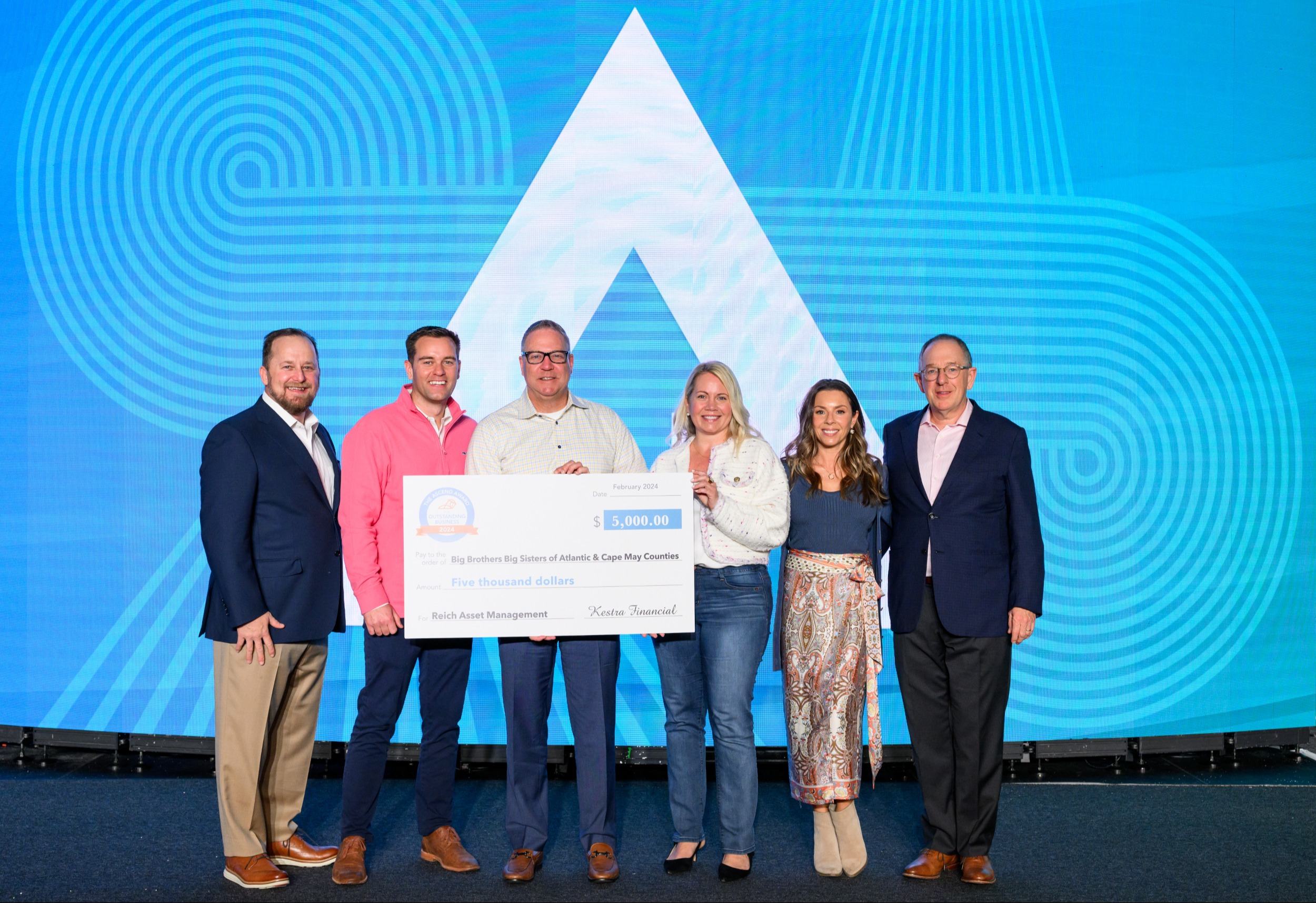 President Stephen Langlois of Kestra Financial and Mark Shoenbeck, EVP, Advisor Engagement at Kestra Financial present T. Eric Reich, President of Reich Asset Management, and his team with a $5,000 check for Big Brothers Big Sisters of Atlantic & Cape May Counties for the 2024 Ascend Award for Outstanding Business.