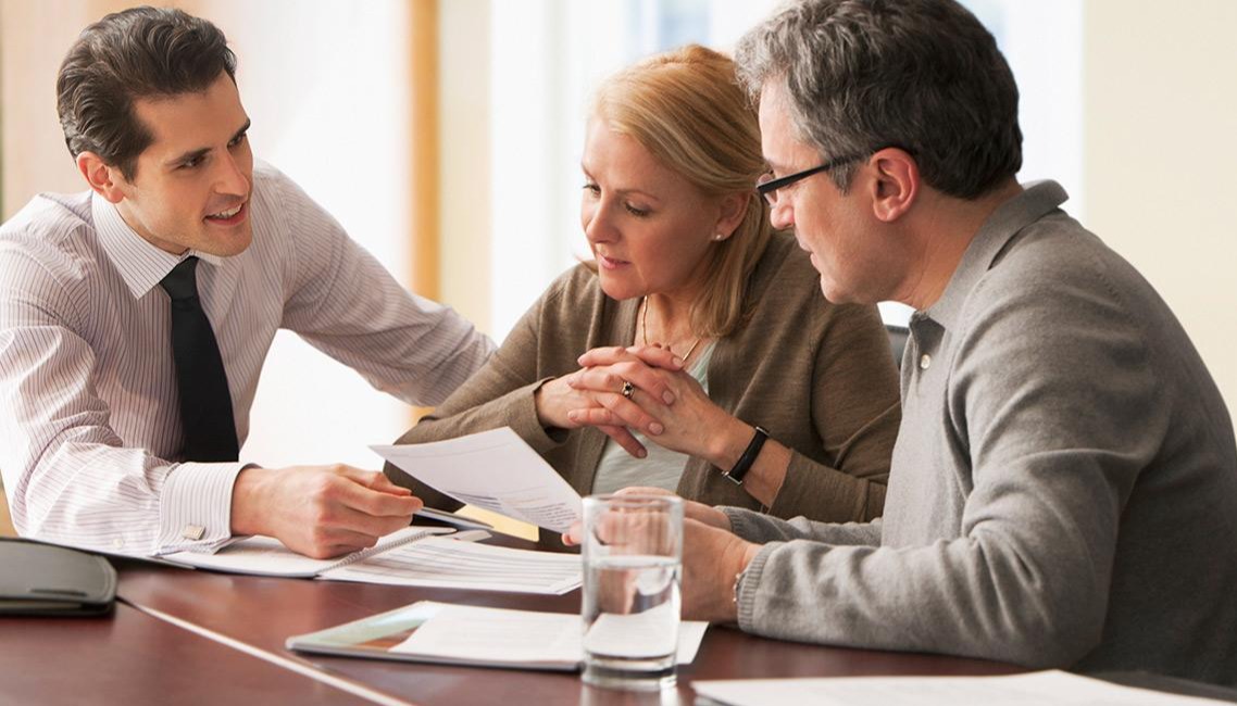 Three business people at a meeting looking at a document