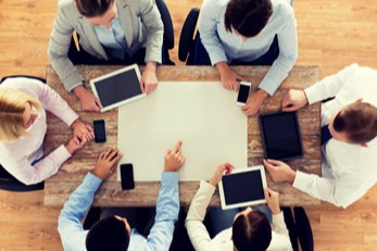 People having a meeting with multiple devices on the table