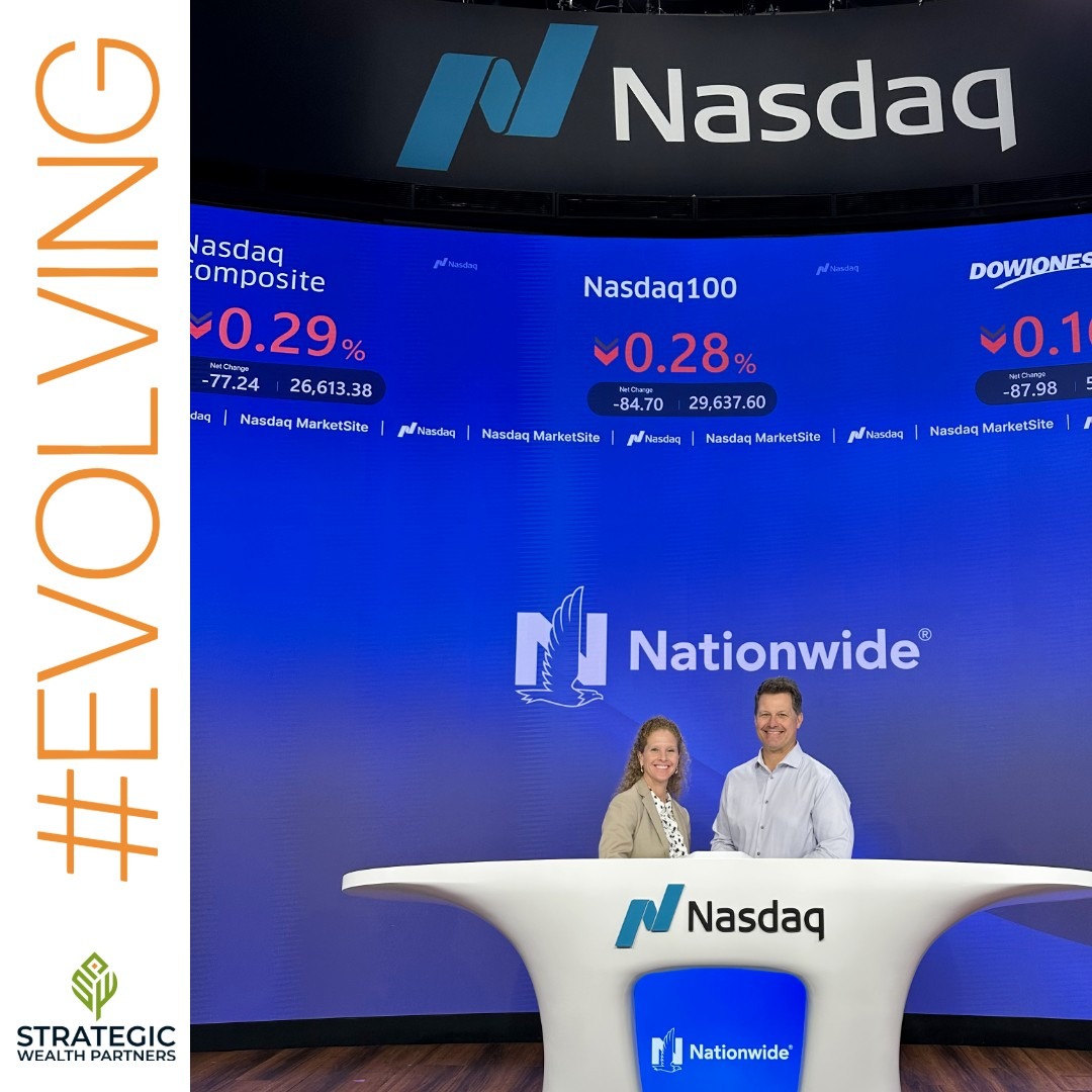 Two SWP team members seated at the Nasdaq MarketSite desk in front of a market display wall