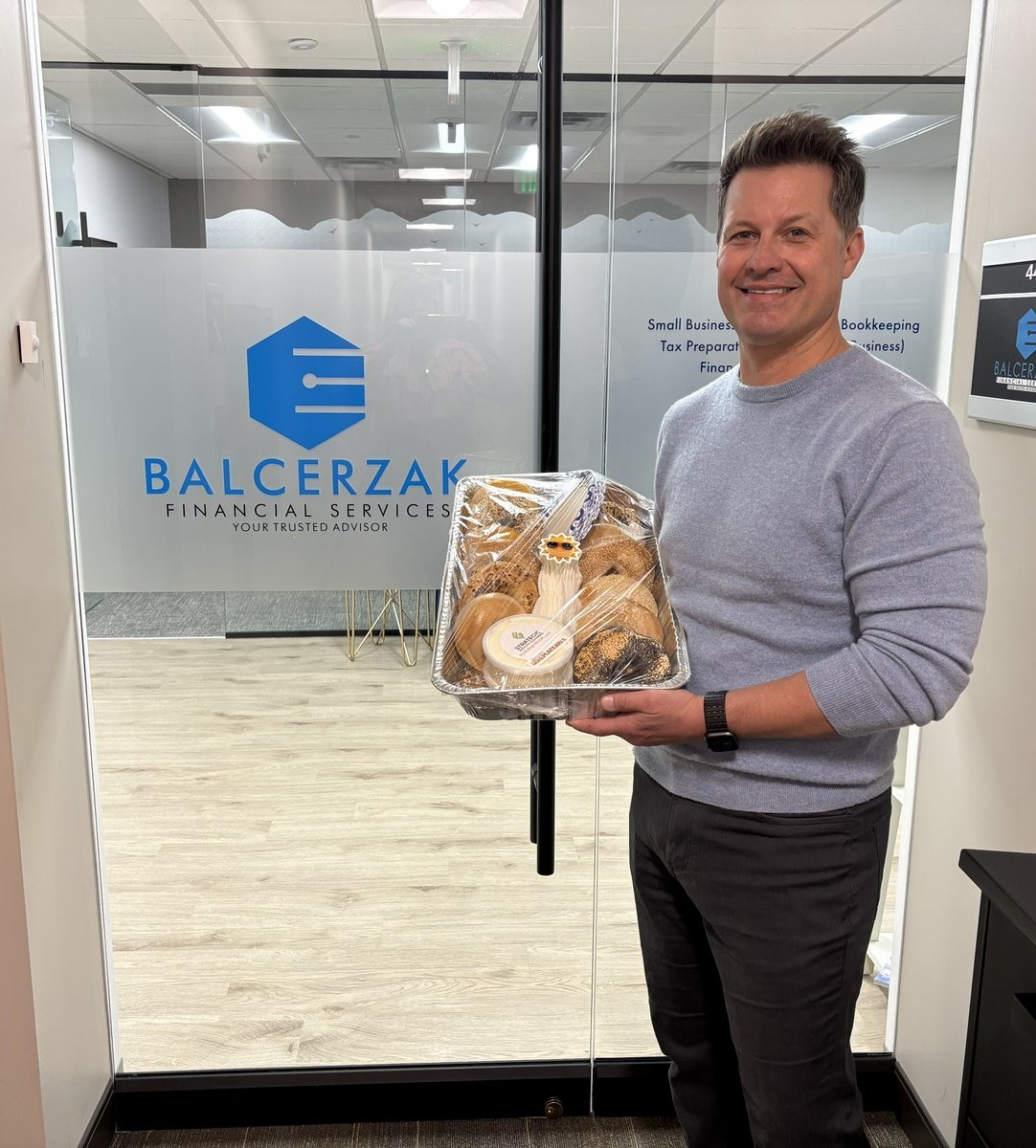 Neill holding a tray of bagels outside a neighboring office suite