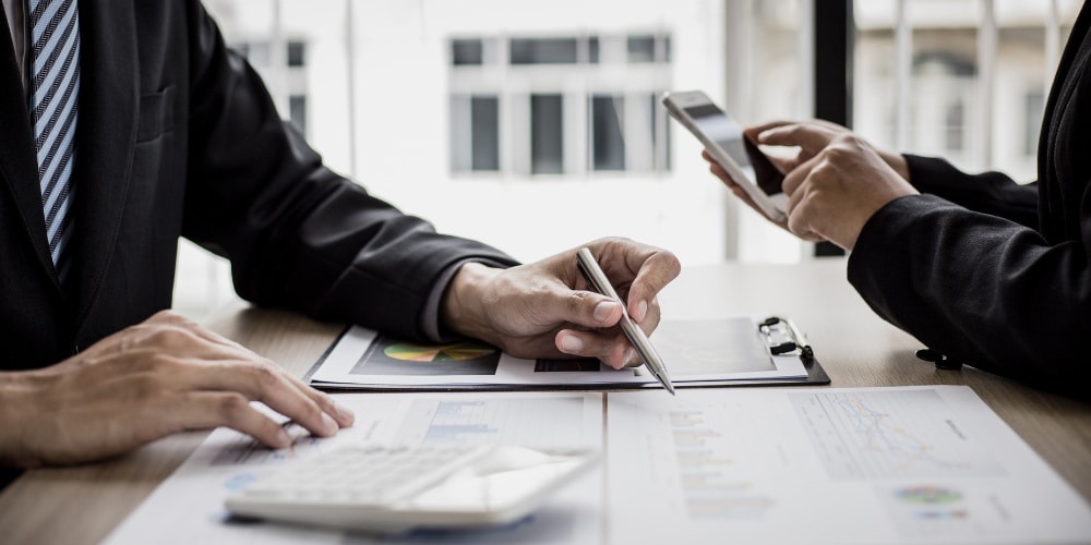 a person reviewing financial documents and data to analyze business performance