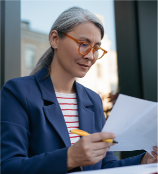 Woman in a suit wearing glasses with a paper in her hands