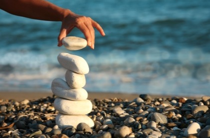 stacking pebbles at a beach