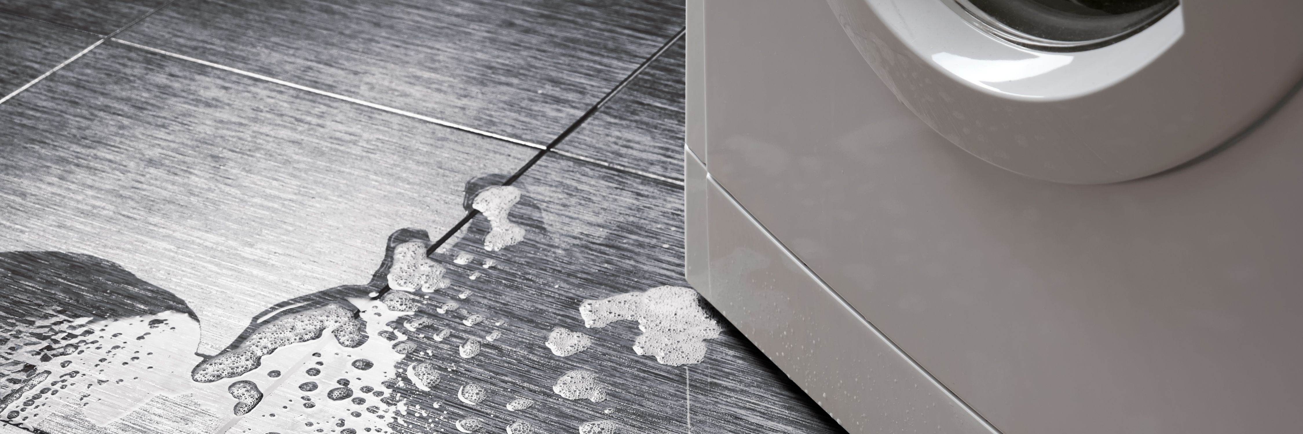 Photo of a washing machine with water on the floor