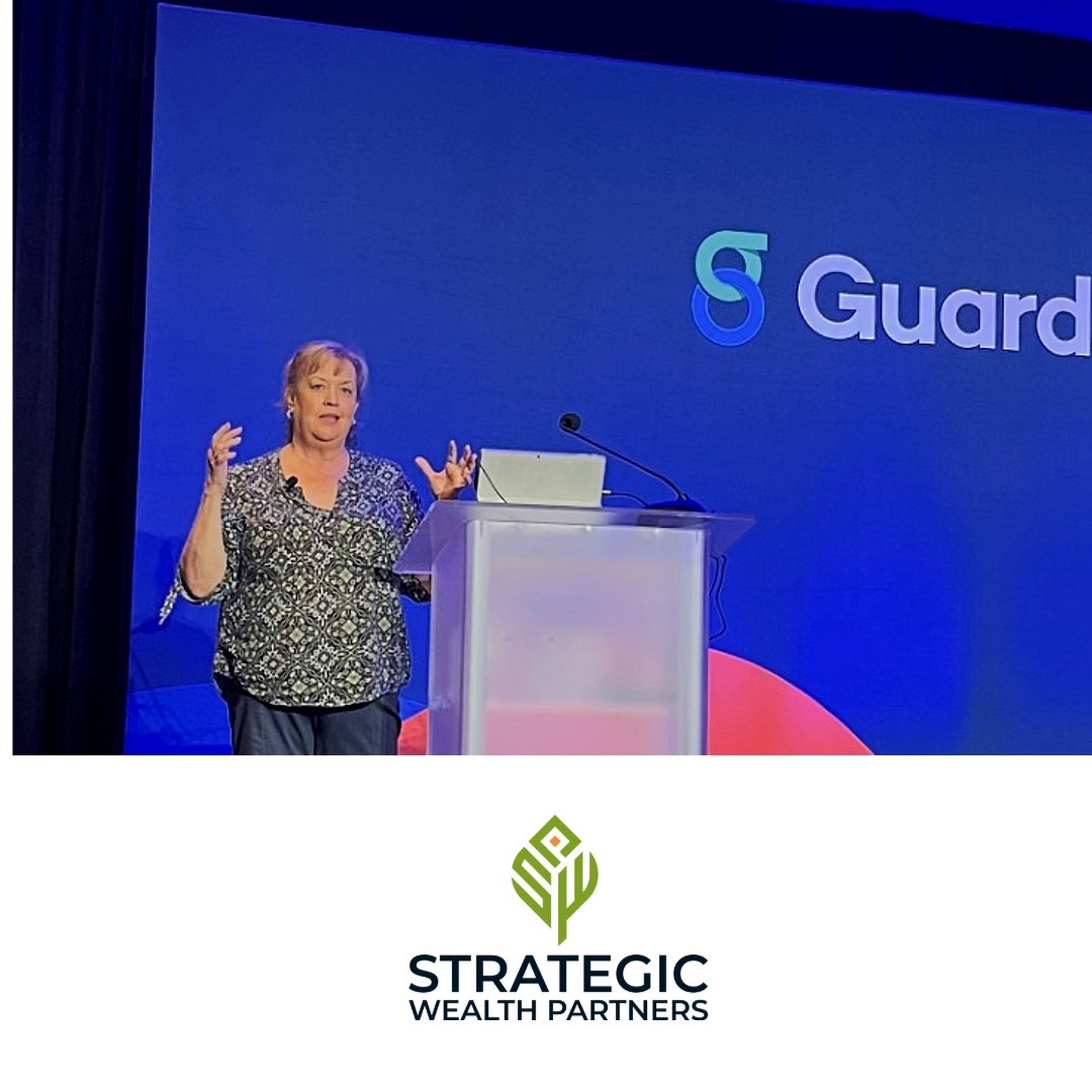 Melissa presenting from a podium in front of a Guardian branded screen