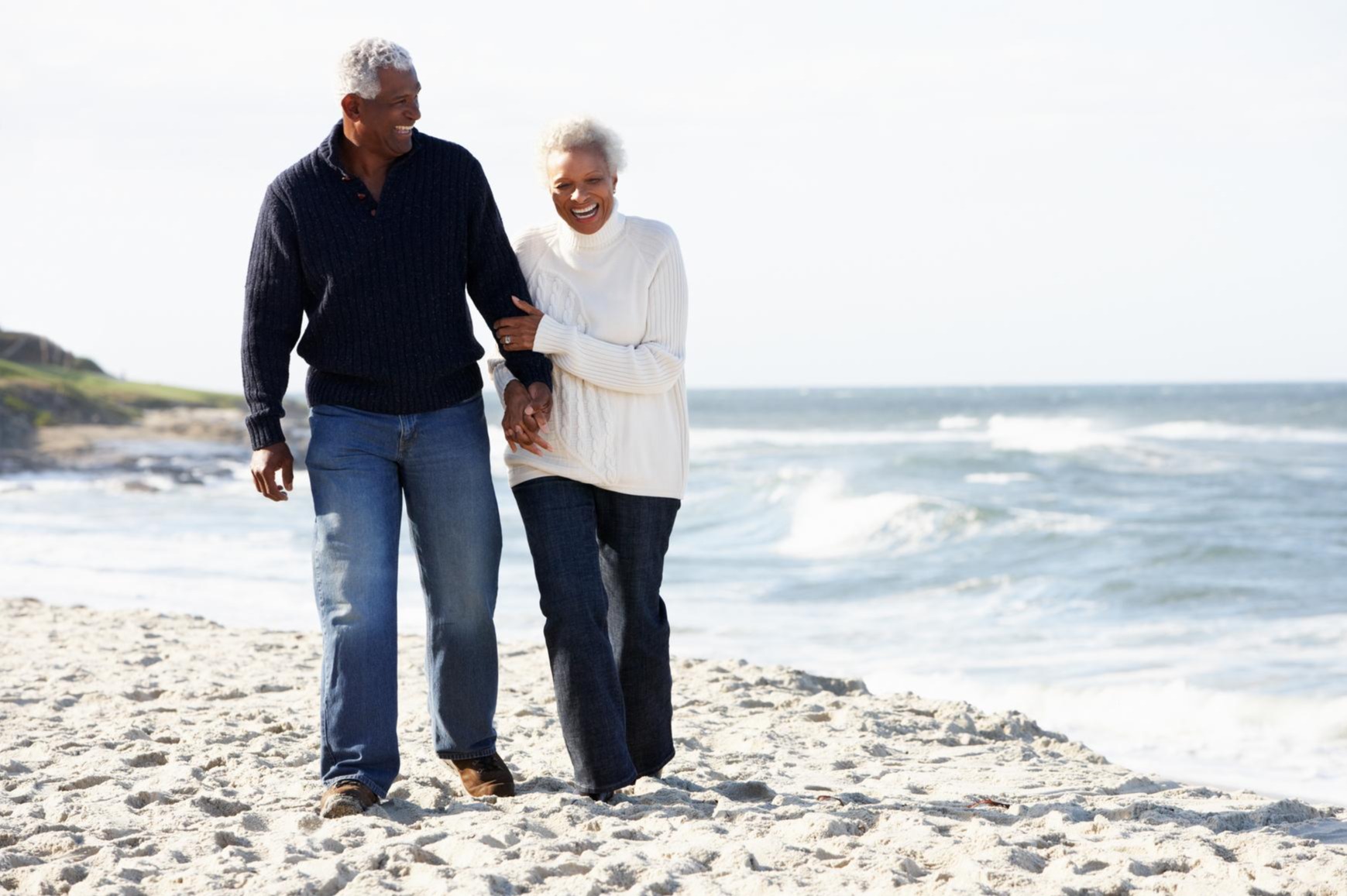 Senior couple walking along the beach together