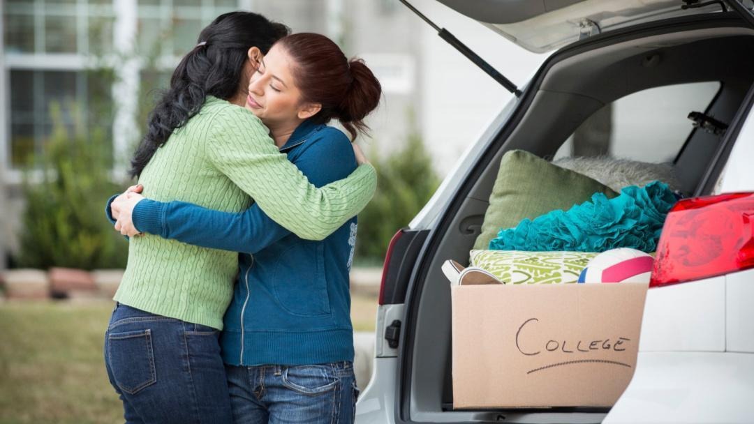 Two woman hugging outside a car