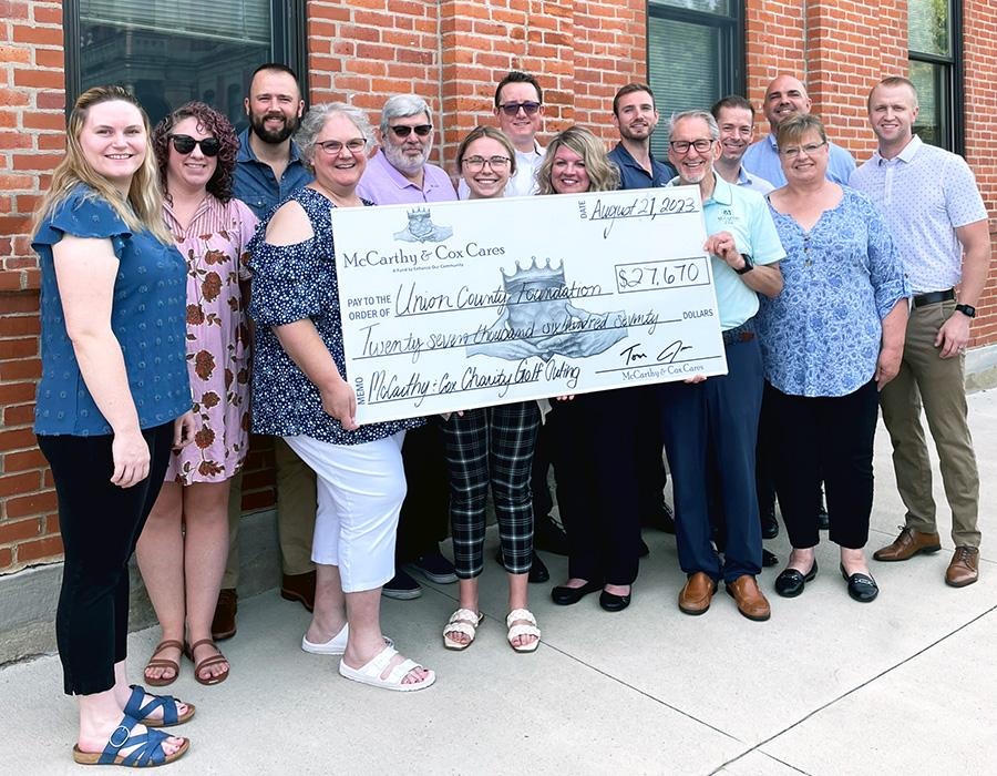 McCarthy and Cox Cares team holding a giant check for the Union County Foundation
