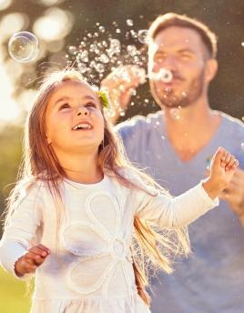 Father and daughter blowing bubbles