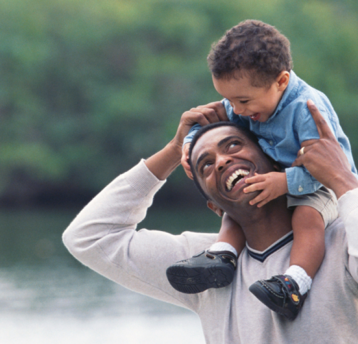 father carrying his young son on his shoulders