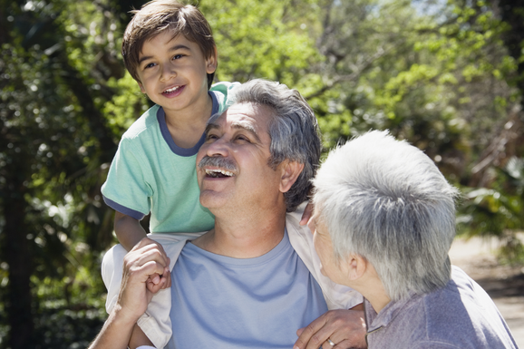 grandfather carrying grandson on shoulders while grandmother looks on