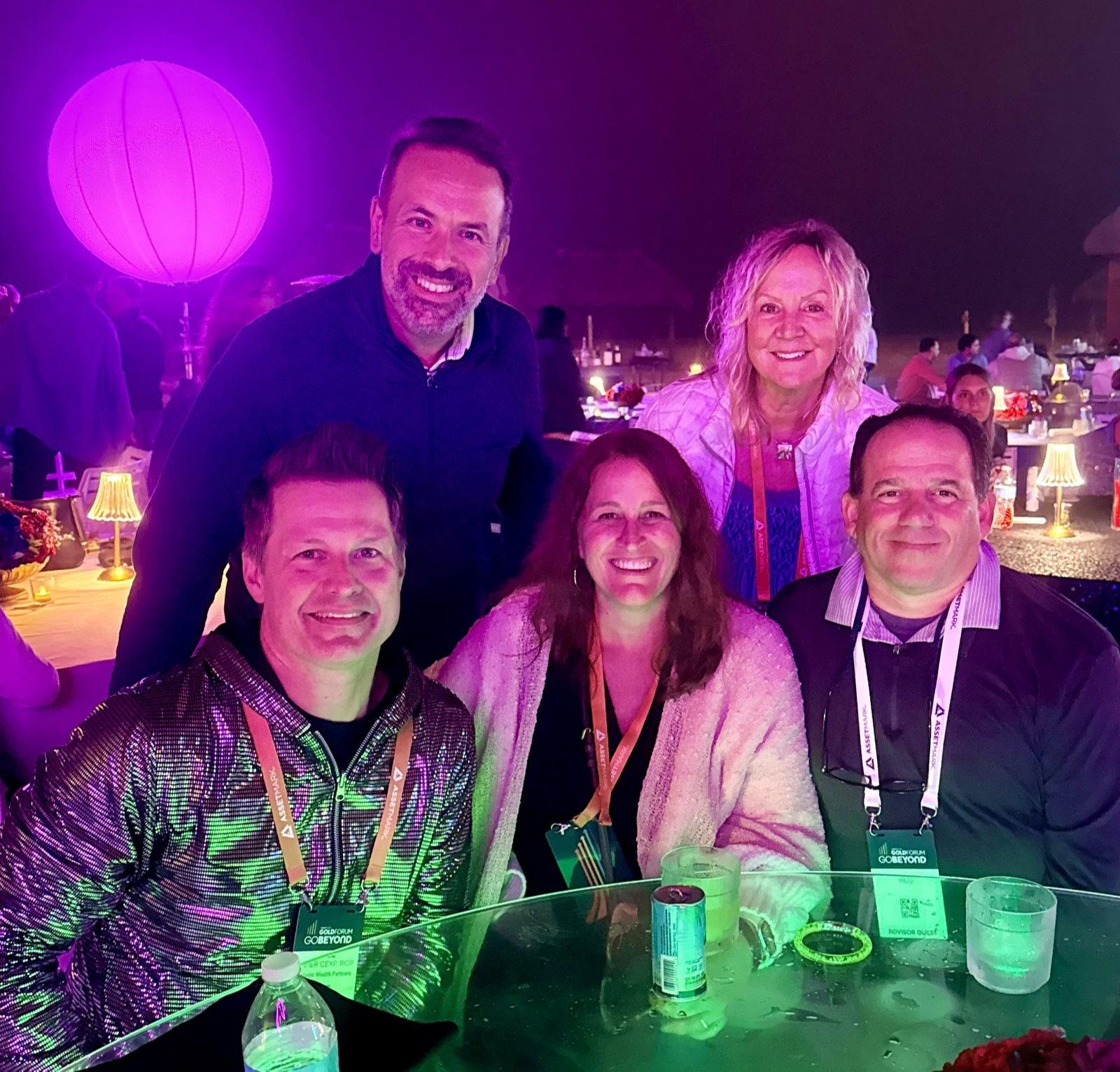 Five people gathered around a lit table at an evening conference reception