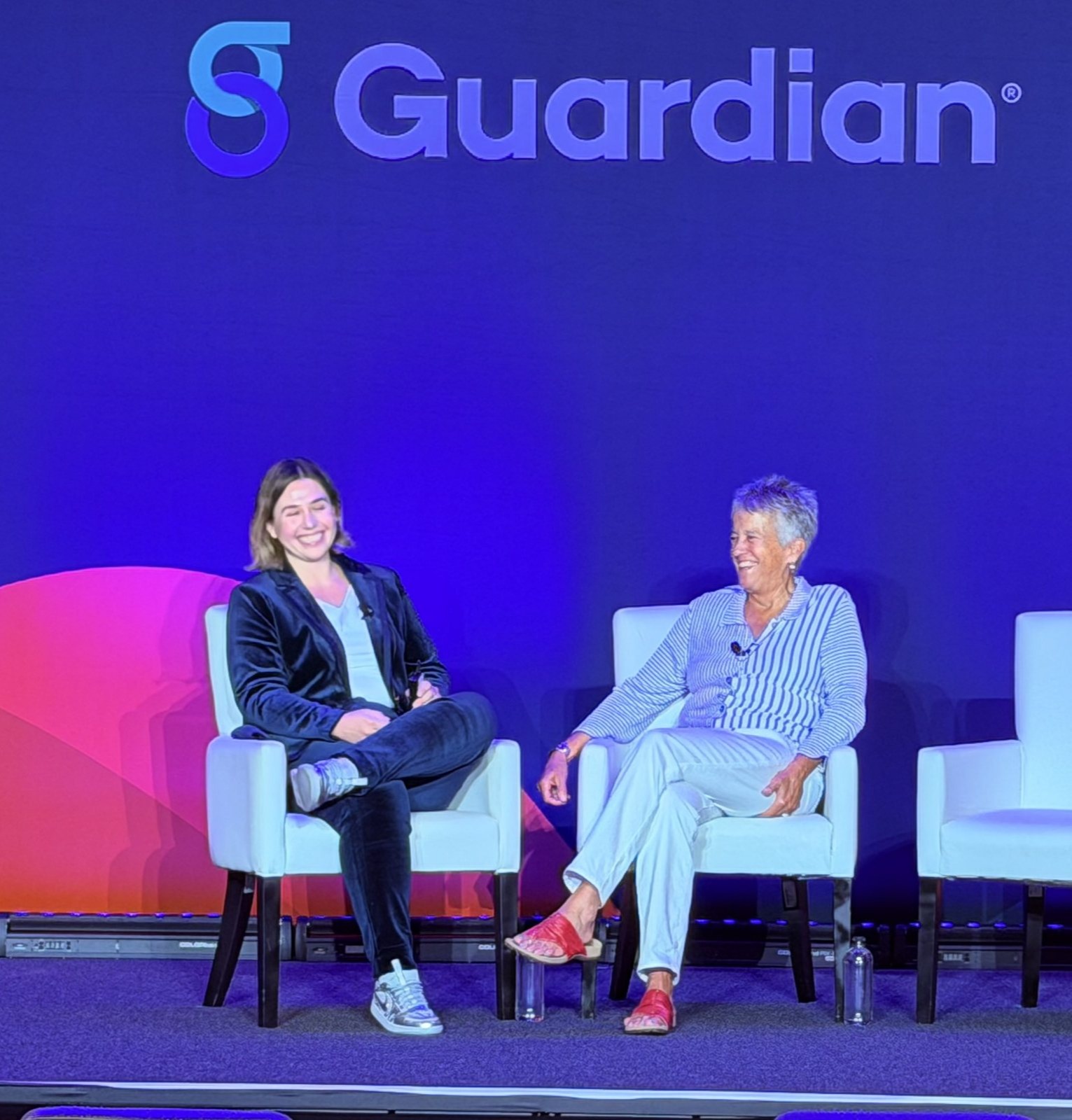 Karen seated on stage in conversation with Megan Henretta beneath a large Guardian logo