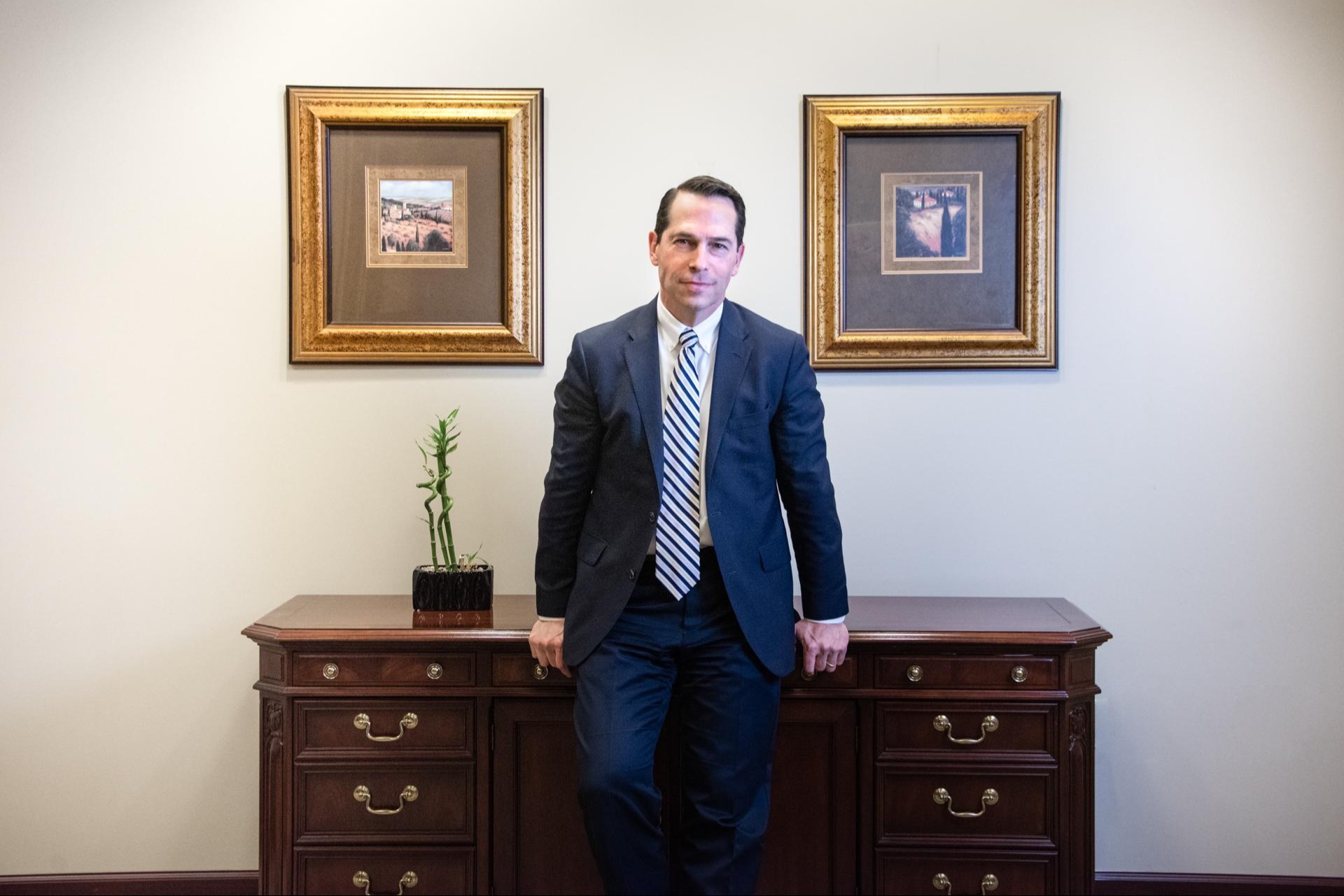 Tom leaning against desk
