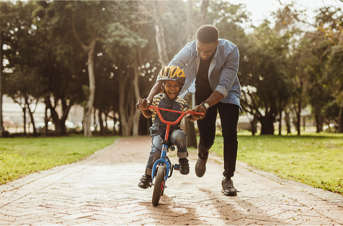 Father teaching son how to ride his bike