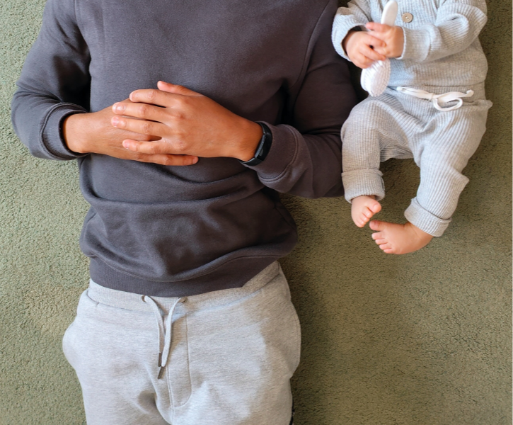 Father laying next to his child on grey carpet