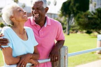 Woman and man leaning on fence and laughing
