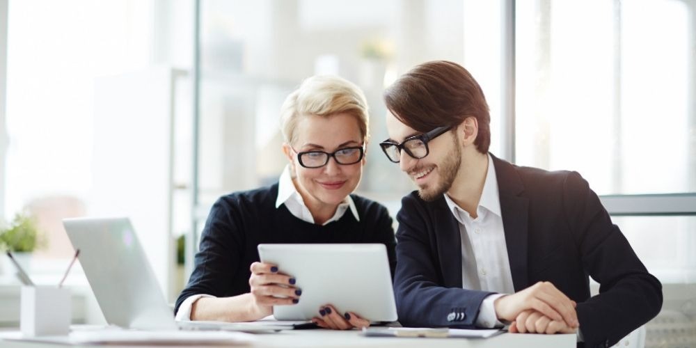 Financial advisors reviewing information on a tablet