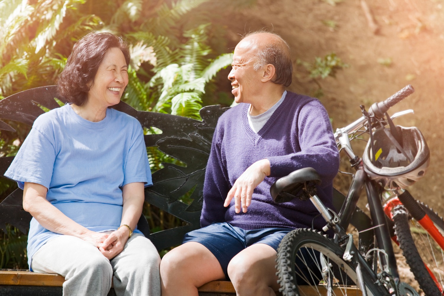 Man and woman having a conversation on a park bench on a sunny day