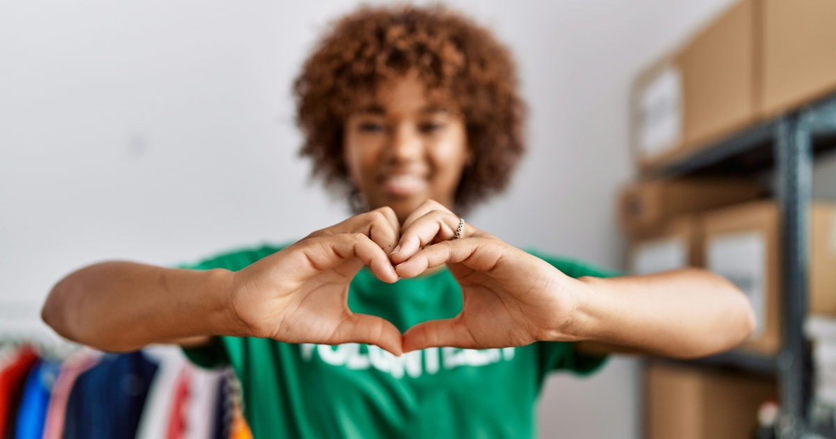 Young woman volunteer holding her hands out in a heart shape