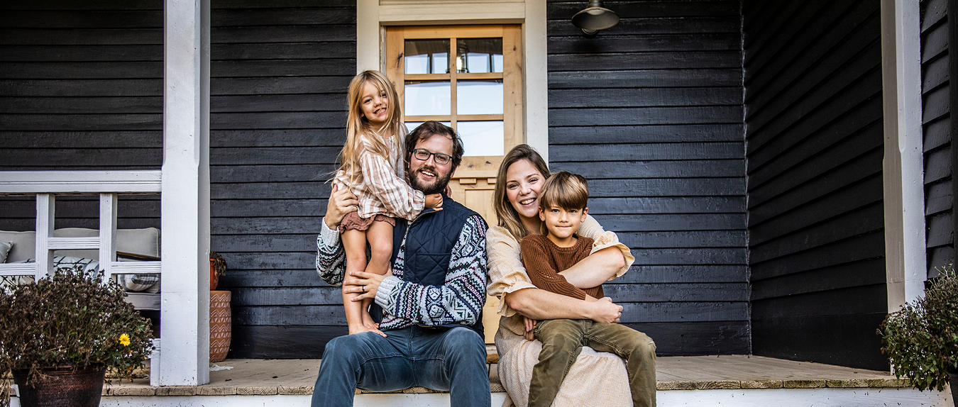 young family in front of their house